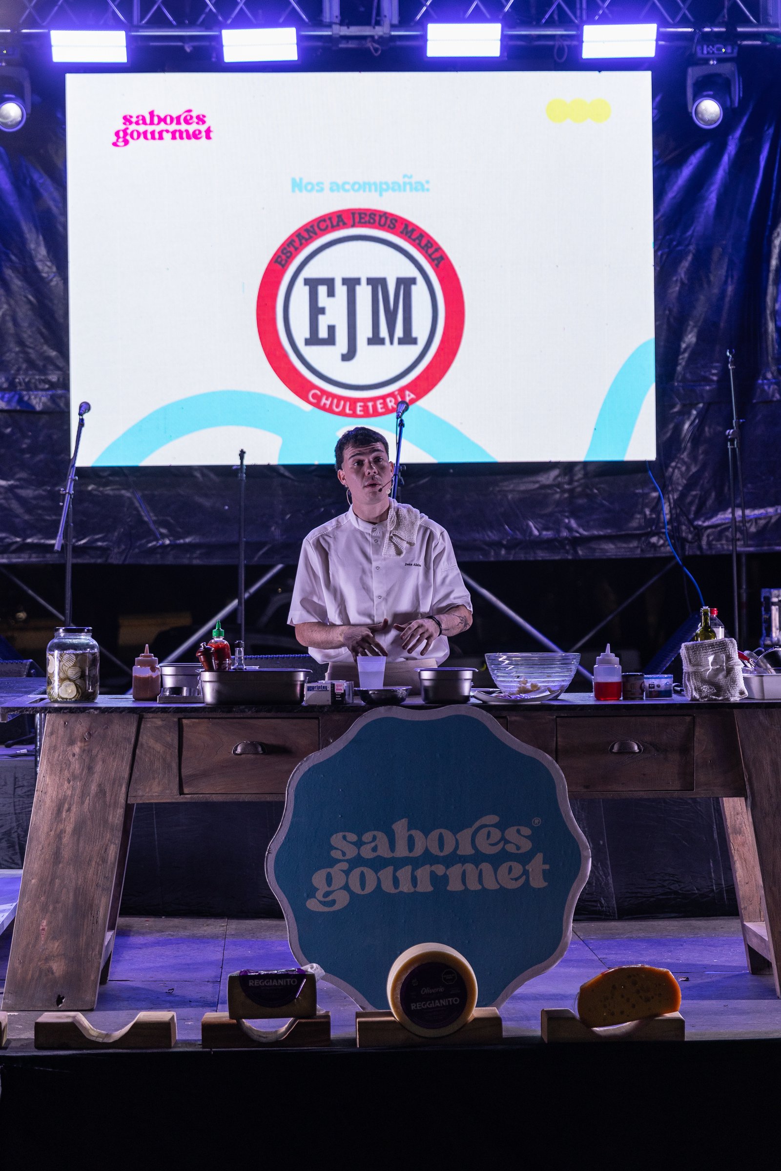 Iván Alsina cocinando sobre el escenario junto a los quesos de Estancia Jesús María
