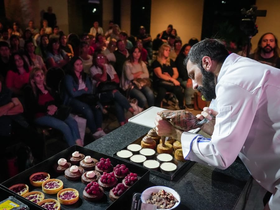 Luciano García mostrando una preparación en un bowl sobre el escenario