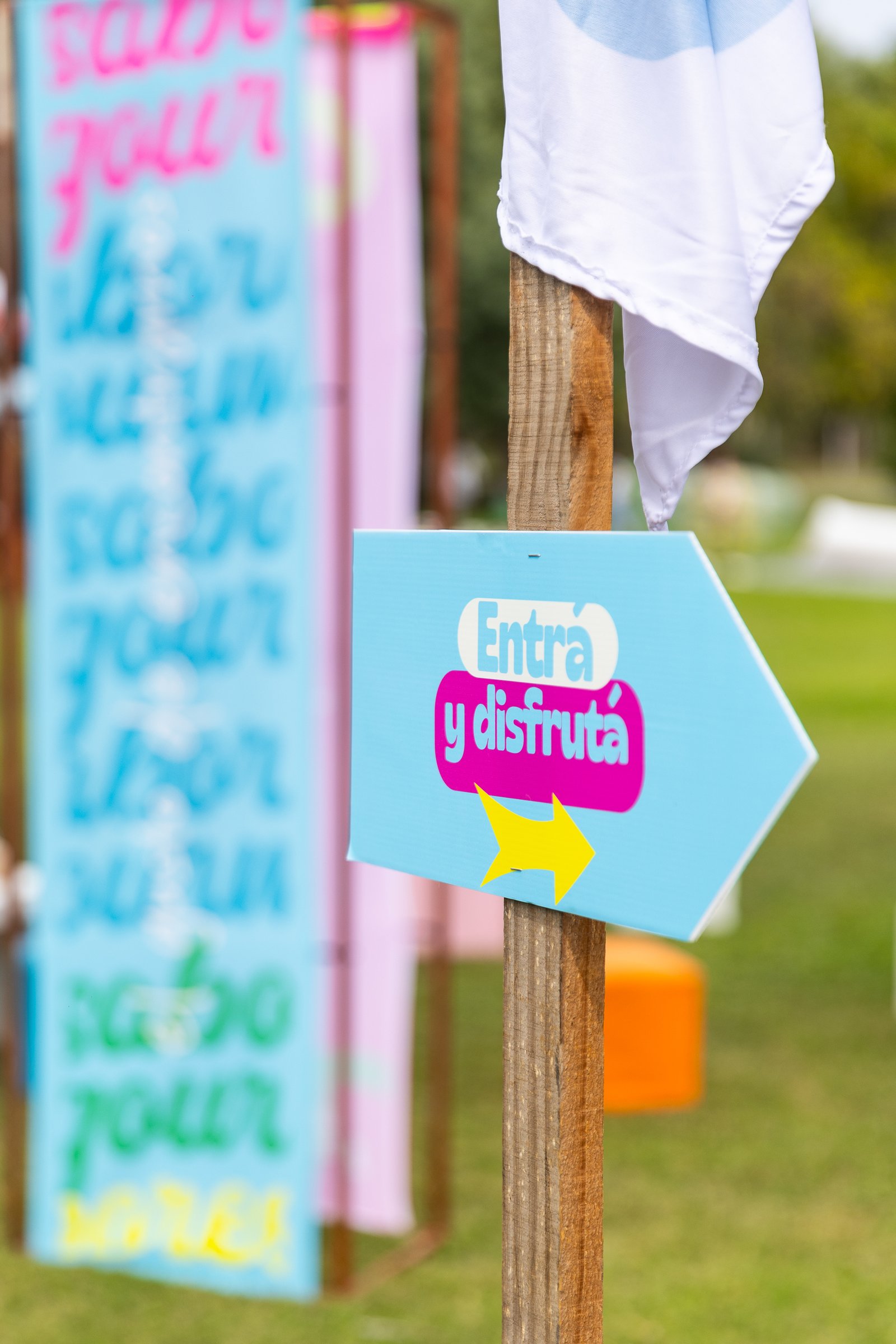 Cartel celeste con flecha que invita a entrar y disfrutar del festival