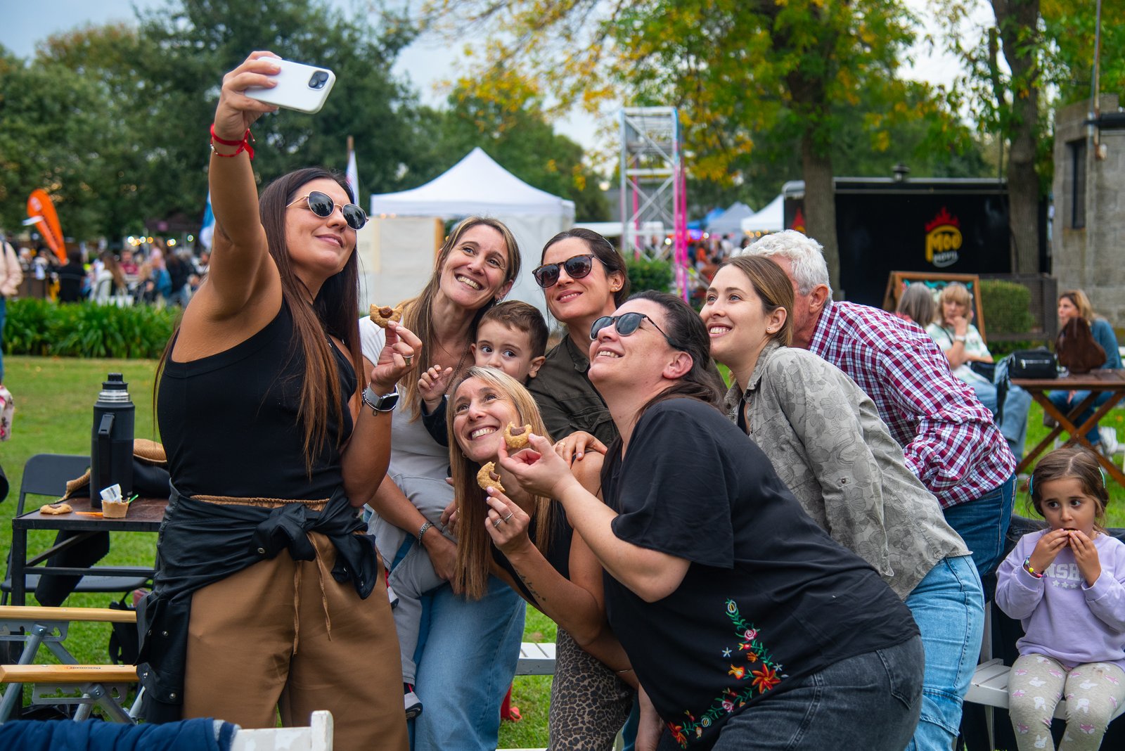 Grupo de amigas y un chico sacándose una selfie mientras comen empanaditas
